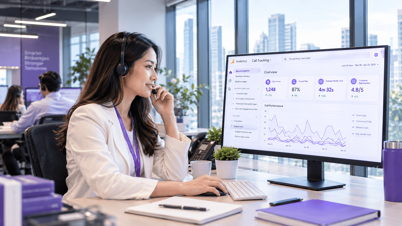 An insurance broker wearing a headset at a brokerage desk, reviewing a call analytics dashboard showing call volume, answer rate and average handle time on a large monitor